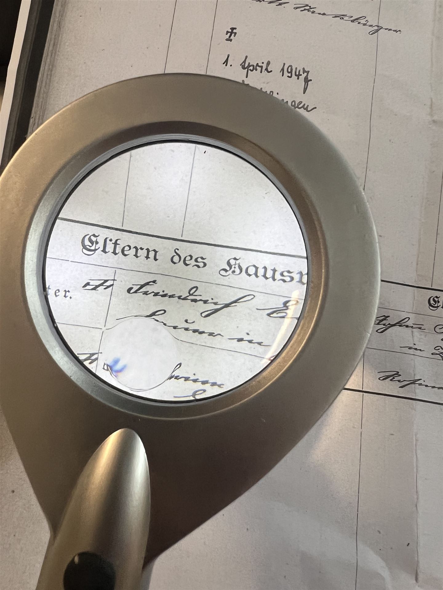 Lupe über einem handschriftlichen historischen Familienregister